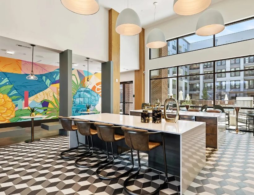 Modern apartment clubroom kitchen with pendant lights and patterned tile floor